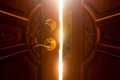 Tür, die sich langsam öffnet. Symbol für Ablehnung, aber mit Licht, das durch die Ritzen fällt